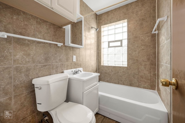 full bathroom with tile walls, toilet, vanity, and shower / tub combination