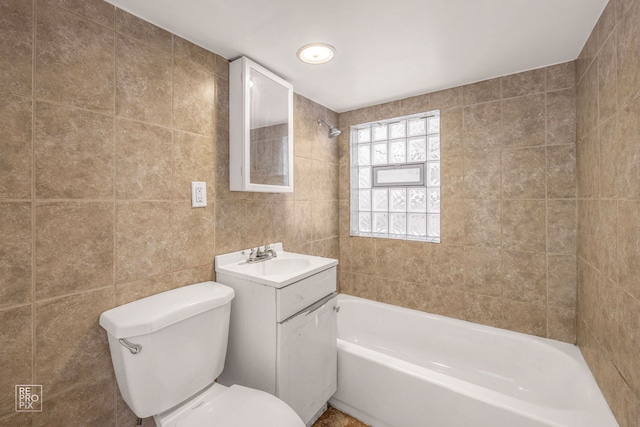 full bathroom with vanity, toilet, tile walls, and tiled shower / bath