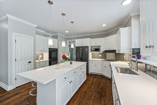 kitchen with a kitchen island, white cabinetry, black appliances, and a sink