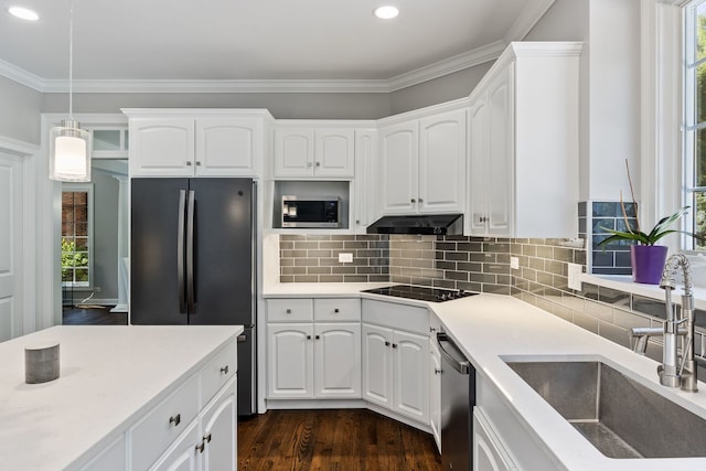 kitchen featuring dark wood-type flooring, under cabinet range hood, ornamental molding, black appliances, and a sink