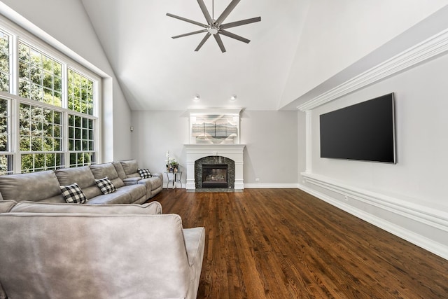 unfurnished living room with wood finished floors, baseboards, a premium fireplace, ceiling fan, and vaulted ceiling