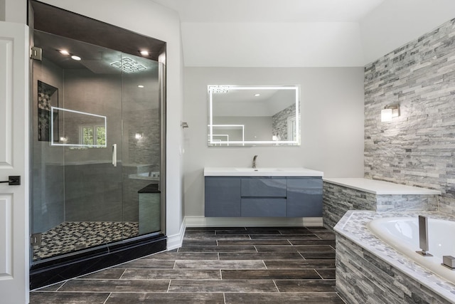 full bath featuring vanity, a shower stall, a bath, and wood finish floors