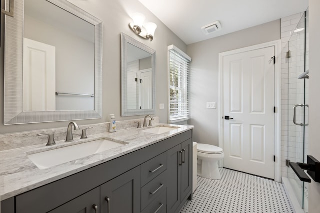 full bathroom with a sink, an enclosed shower, toilet, and double vanity