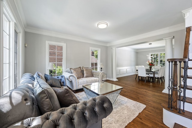 living room with dark wood-style floors, crown molding, and ornate columns