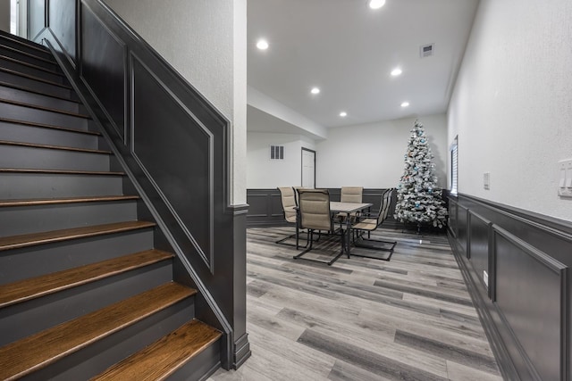 interior space with visible vents, recessed lighting, a wainscoted wall, and wood finished floors