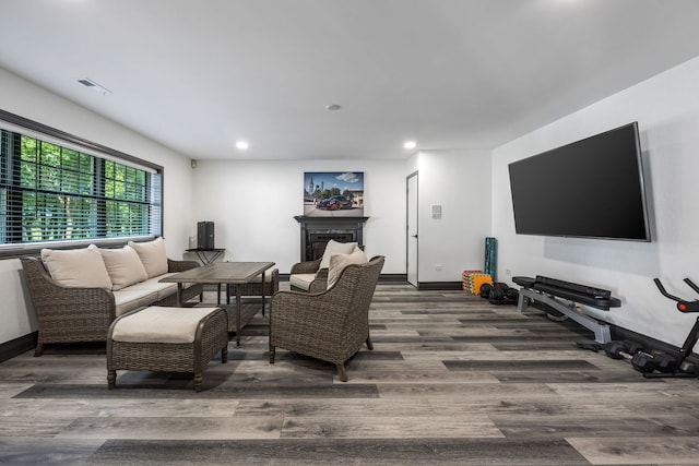 living room featuring recessed lighting, baseboards, wood finished floors, and a fireplace