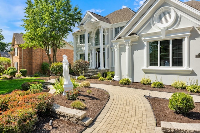 view of front of property featuring stucco siding and a shingled roof