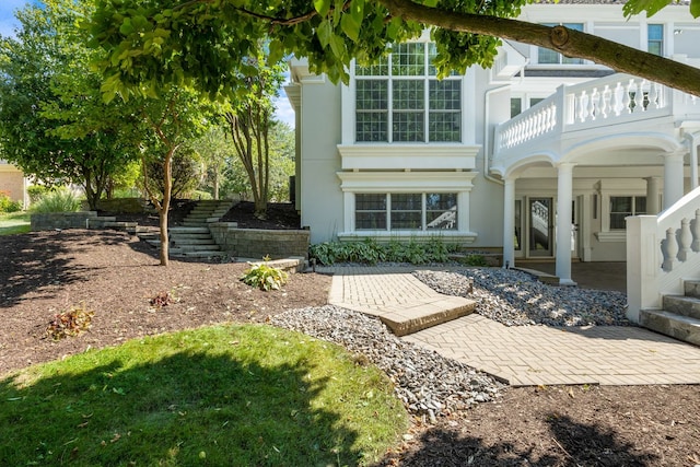 rear view of house with stucco siding and a balcony