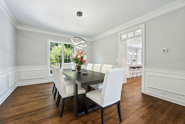 dining area with wainscoting, a chandelier, dark wood-style flooring, and ornamental molding