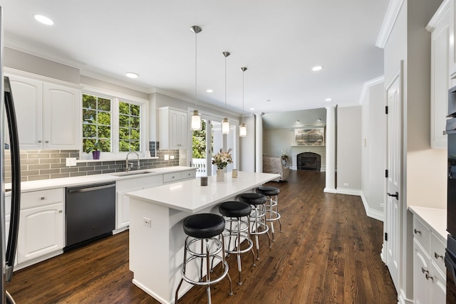 kitchen with dishwashing machine, ornamental molding, a sink, backsplash, and a center island