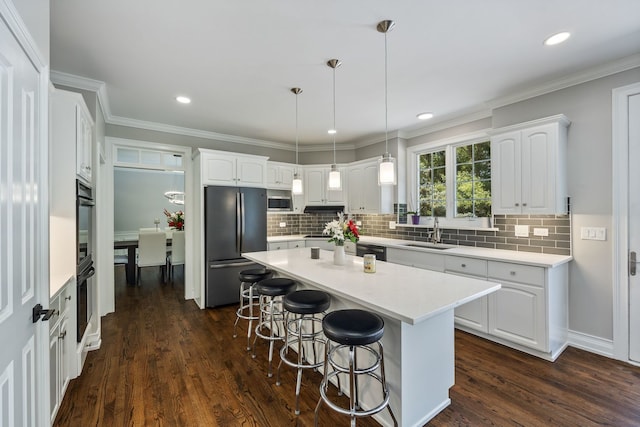 kitchen with black appliances, a breakfast bar, a sink, white cabinets, and dark wood-style flooring