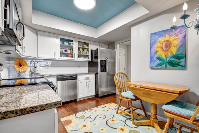 kitchen with light stone counters, appliances with stainless steel finishes, and white cabinets