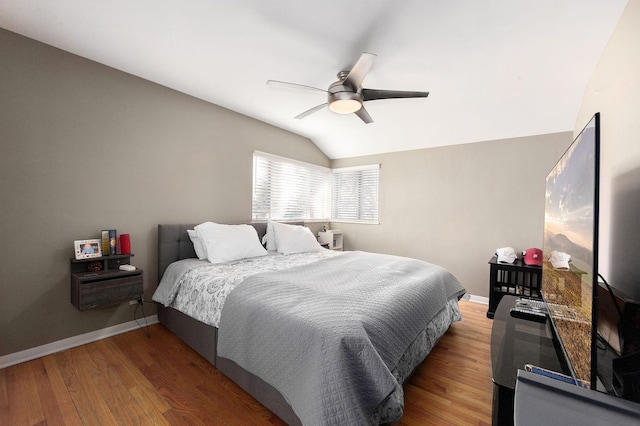 bedroom with ceiling fan, vaulted ceiling, and wood-type flooring