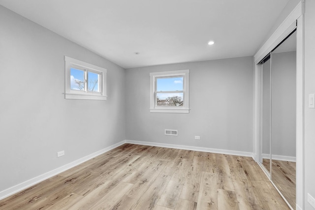 unfurnished bedroom featuring light hardwood / wood-style floors and a closet