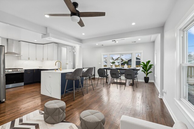 unfurnished living room featuring dark hardwood / wood-style flooring, sink, and ceiling fan with notable chandelier