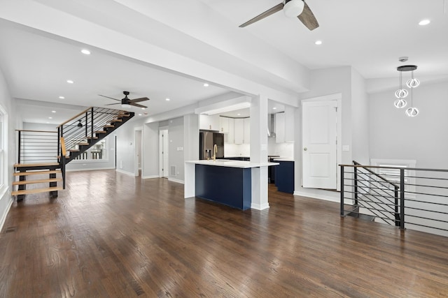 unfurnished living room with sink, dark wood-type flooring, and ceiling fan with notable chandelier