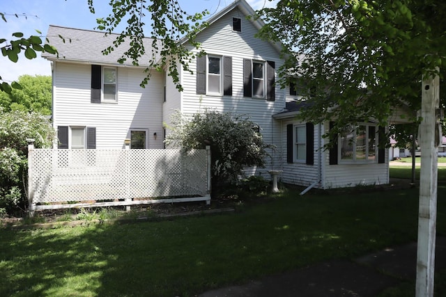 rear view of house featuring a lawn