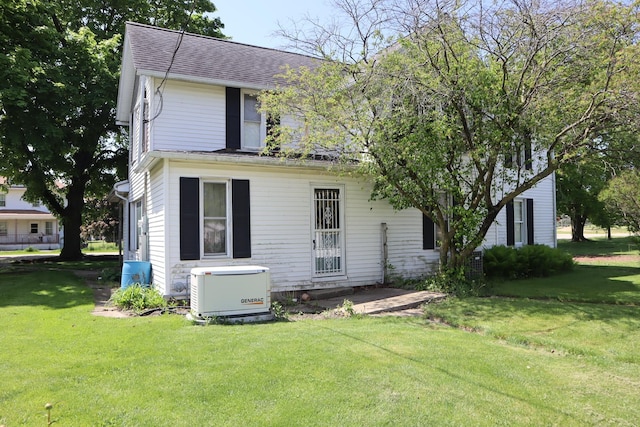 rear view of house featuring a yard