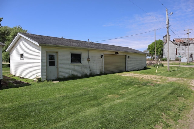 back of house with a yard and a garage