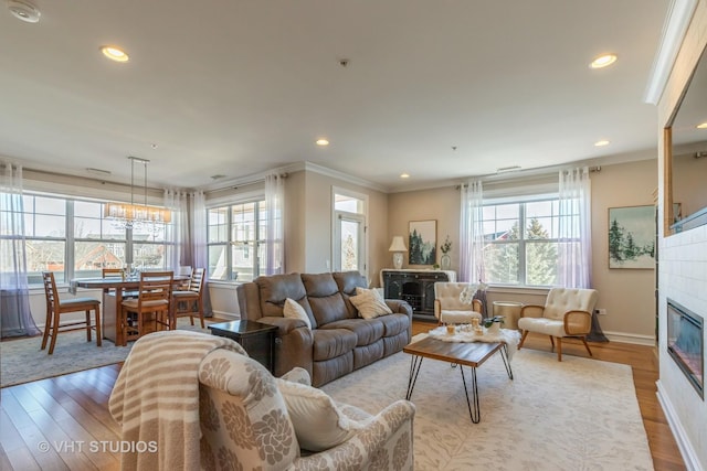 living room featuring crown molding, wood-type flooring, and a wealth of natural light