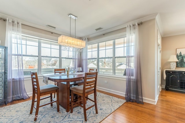 dining room featuring crown molding and light hardwood / wood-style floors