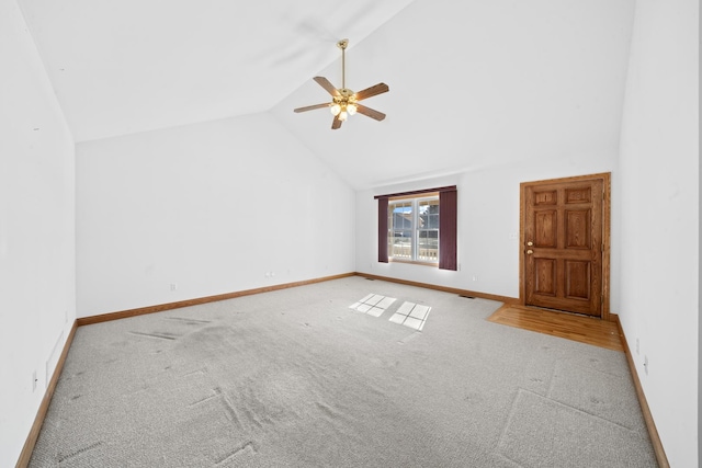 interior space featuring ceiling fan, high vaulted ceiling, and light carpet