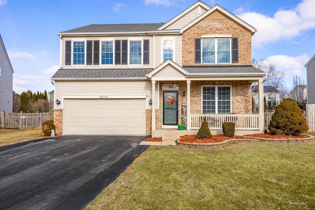 view of front of home with a garage, a front lawn, and covered porch