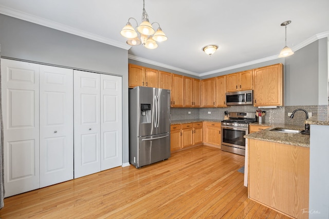 kitchen featuring pendant lighting, appliances with stainless steel finishes, tasteful backsplash, and sink