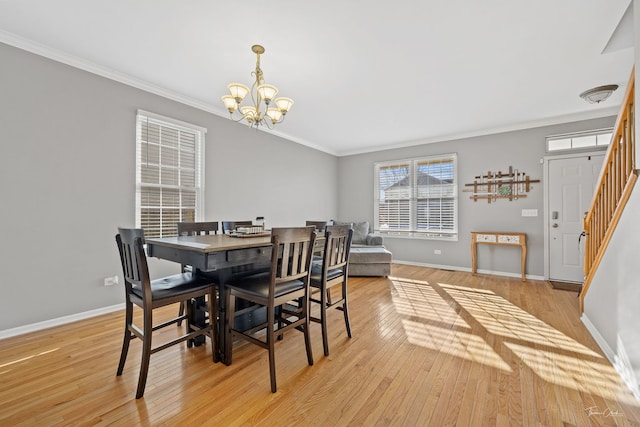 dining area featuring crown molding, light hardwood / wood-style floors, and an inviting chandelier