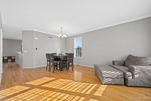 dining area with crown molding, hardwood / wood-style floors, and an inviting chandelier