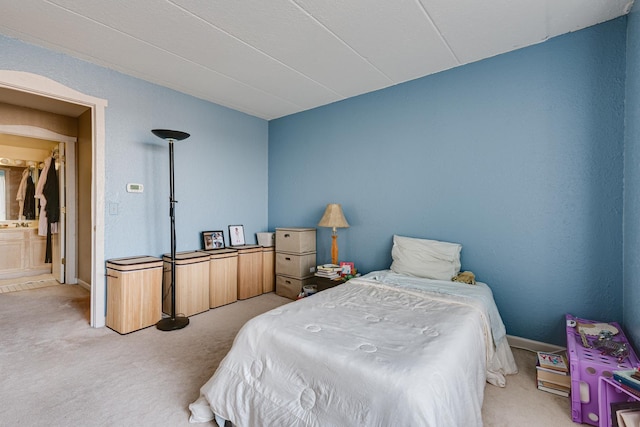 carpeted bedroom featuring ensuite bath