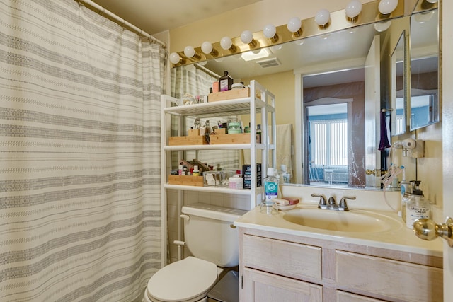 bathroom with vanity, toilet, and curtained shower