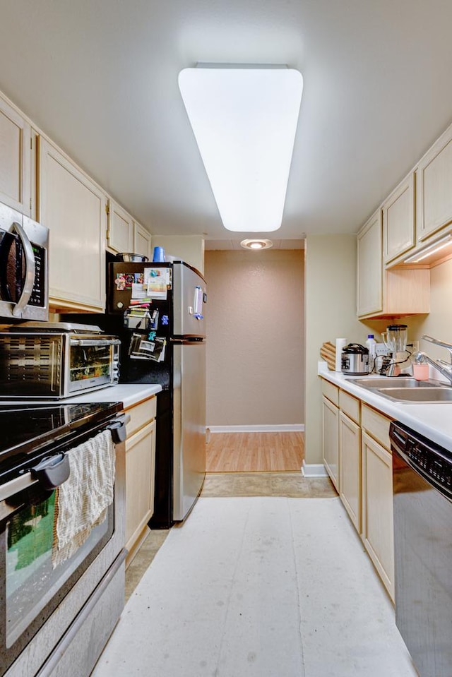 kitchen with appliances with stainless steel finishes, sink, and light wood-type flooring