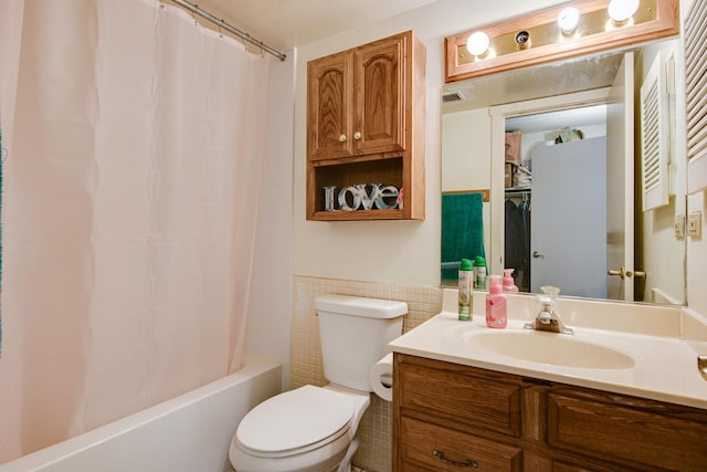 full bathroom with shower / bath combo with shower curtain, vanity, toilet, and tile walls