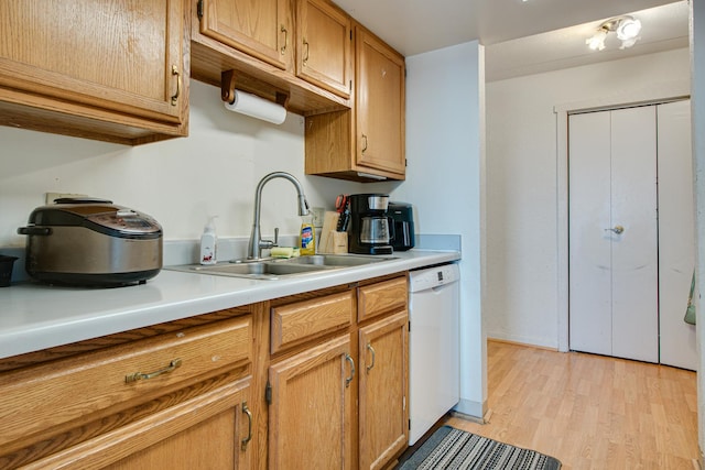 kitchen featuring sink, white dishwasher, and light hardwood / wood-style flooring