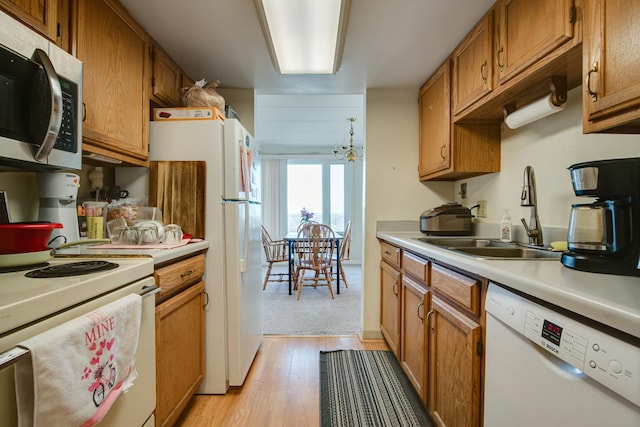 kitchen with sink, white appliances, and light hardwood / wood-style flooring