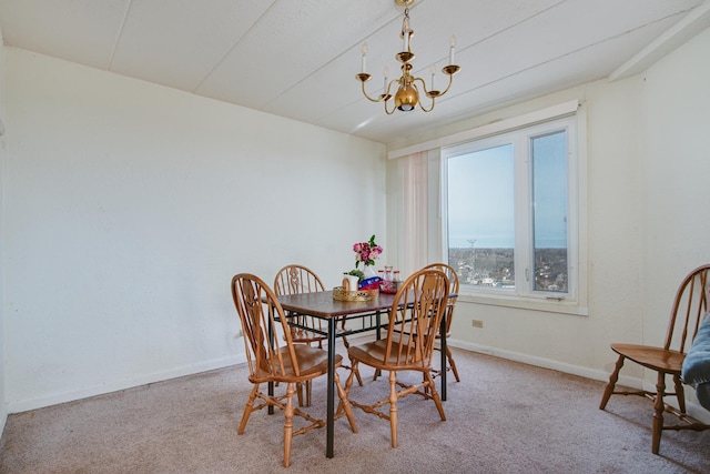 carpeted dining space featuring a chandelier