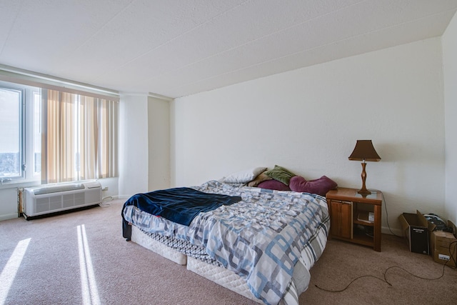 bedroom with carpet floors and a wall unit AC