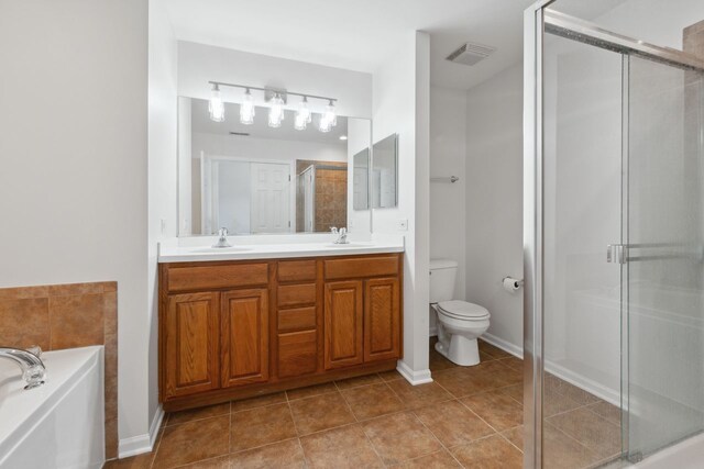 bathroom with walk in shower, vanity, and toilet