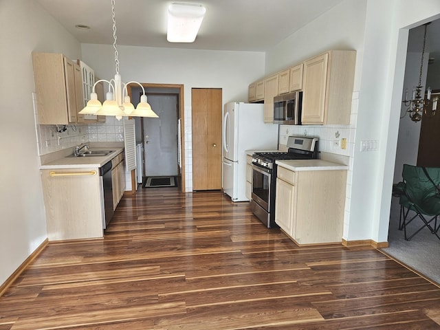 kitchen featuring sink, backsplash, stainless steel appliances, a notable chandelier, and dark hardwood / wood-style flooring