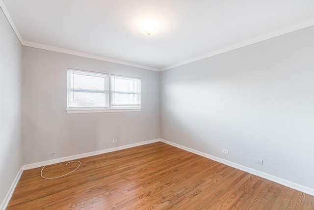 empty room featuring light wood-type flooring and ornamental molding