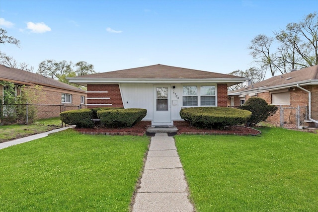 bungalow with fence, a front yard, and brick siding
