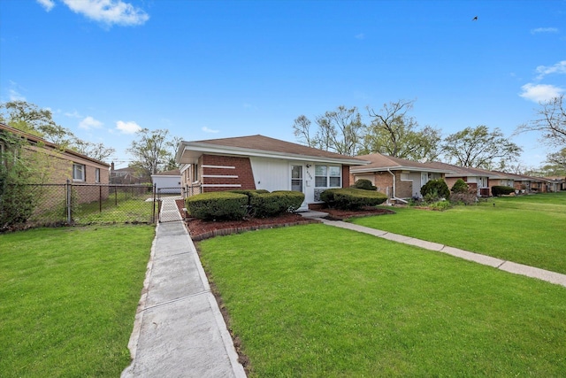 view of front facade with a front lawn, a gate, brick siding, and fence