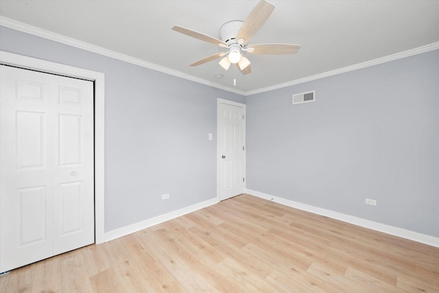 unfurnished bedroom with crown molding, ceiling fan, visible vents, baseboards, and light wood-type flooring