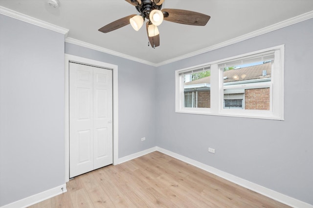 unfurnished bedroom featuring light wood finished floors, a closet, ceiling fan, crown molding, and baseboards