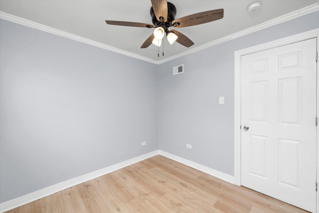 empty room featuring light wood-style floors, ceiling fan, crown molding, visible vents, and baseboards