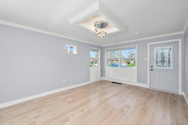 entrance foyer featuring light wood-style floors, baseboards, visible vents, a textured ceiling, and crown molding