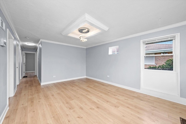 spare room featuring crown molding, a textured ceiling, baseboards, and light wood-type flooring