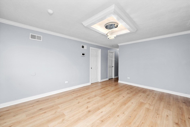 unfurnished room featuring ornamental molding, visible vents, light wood-style flooring, and baseboards