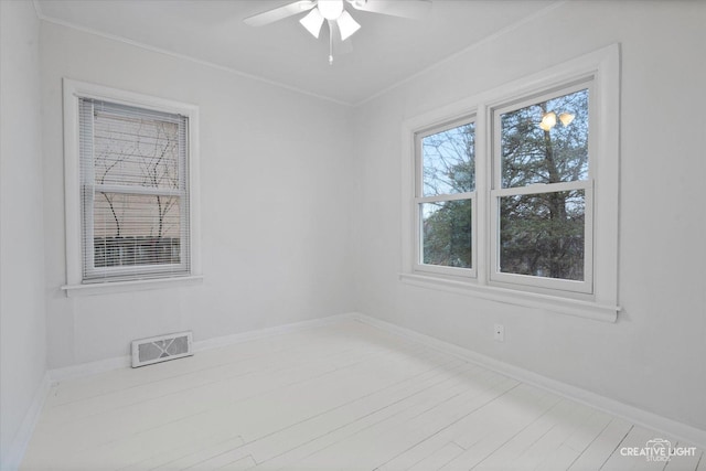 empty room featuring ornamental molding, ceiling fan, and light wood-type flooring